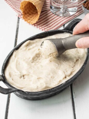 Scooping banana ice cream from an oval dish