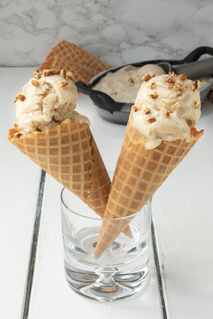 2 waffle cones with banana ice cream standing up in a glass