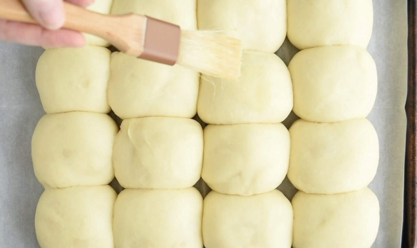 Brushing egg wash on rolls