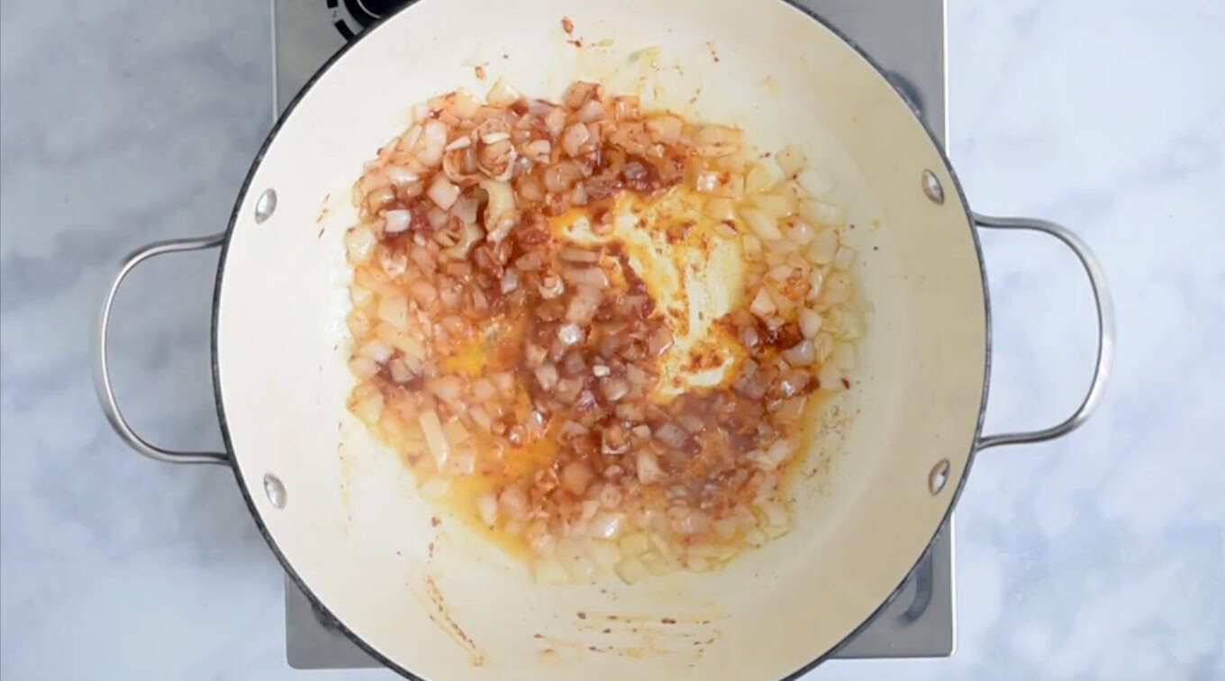 Tomato paste mixed into onions and garlic