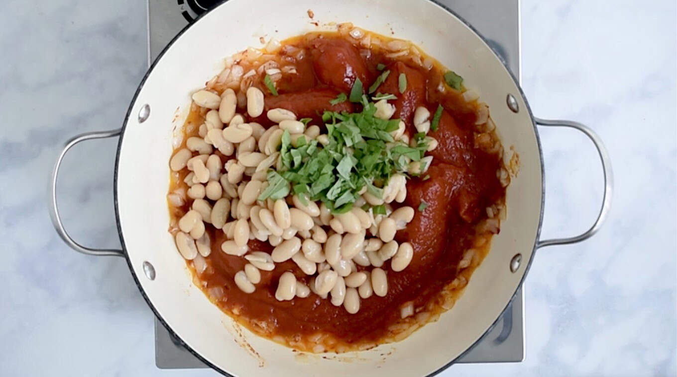 Beans, basil and tomatoes in a pan