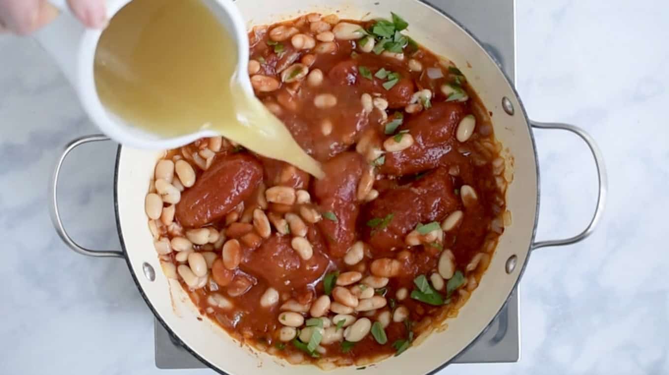 Pouring vegetable stock into a pan