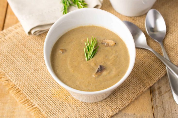 Vegan mushroom soup in a white bowl with 2 spoons