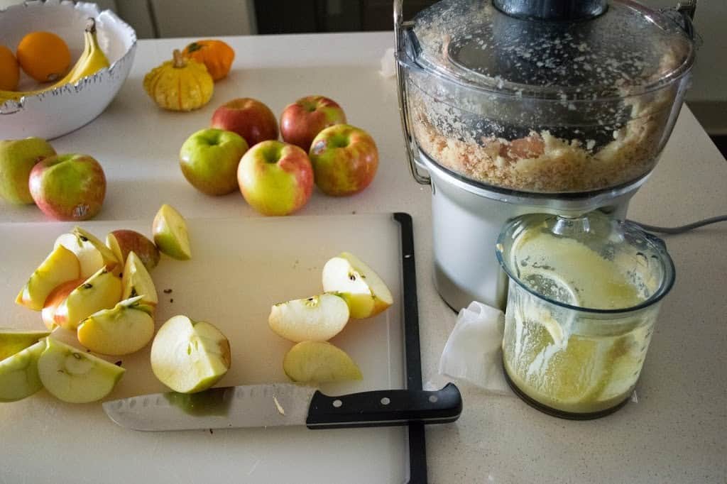 Apples being put through a juicer