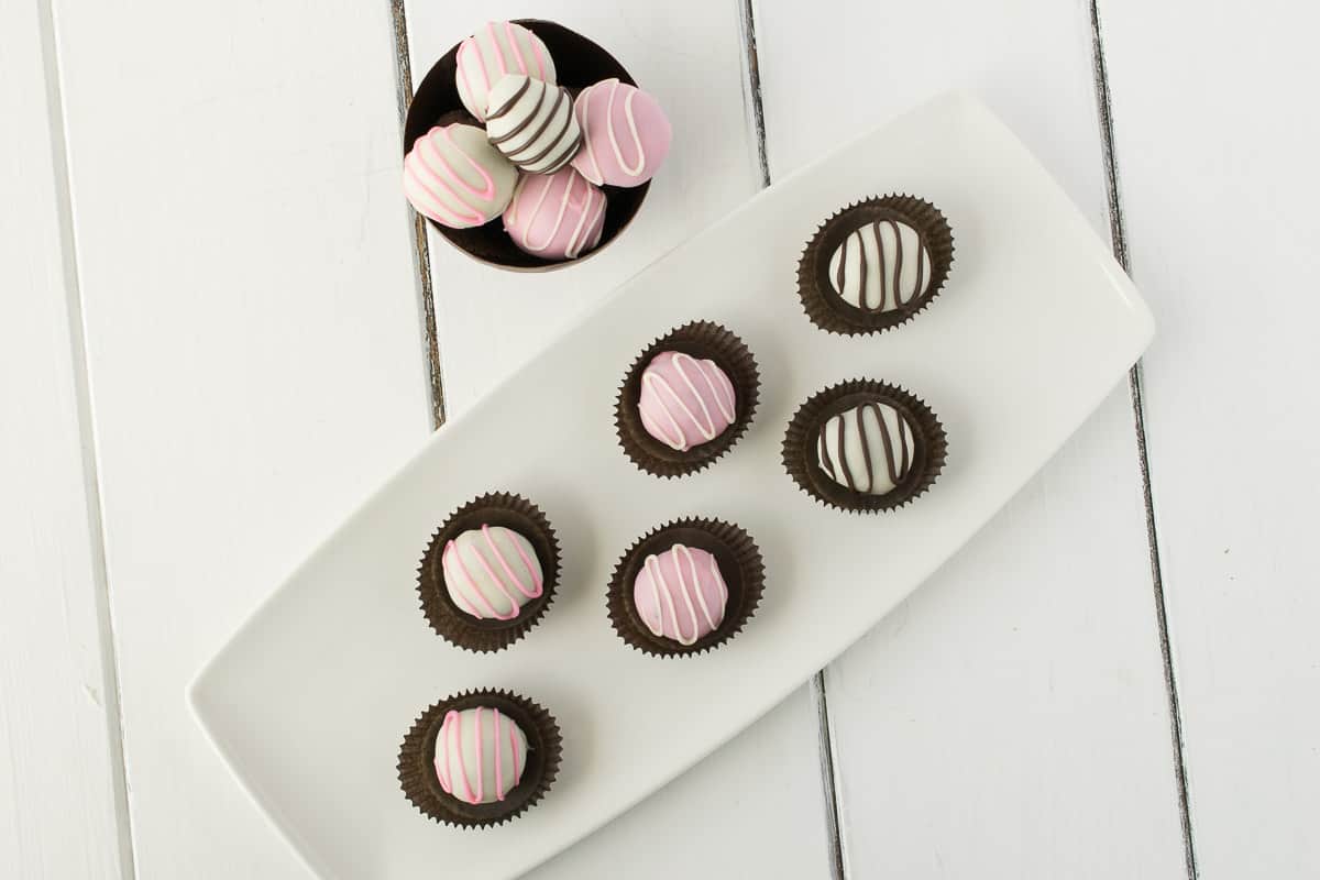 Chocolate truffles in paper cups on a white plate