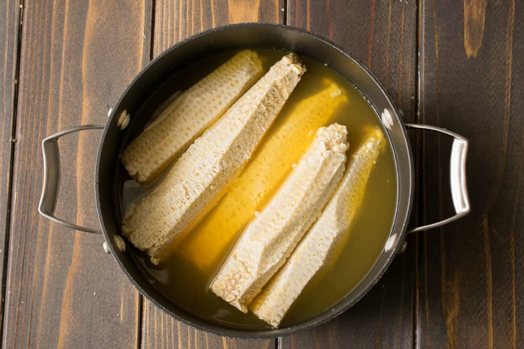 Corn Cobbs in a pan with vegetable broth to  make corn broth