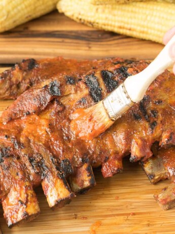 Brushing barbecue sauce on spare ribs