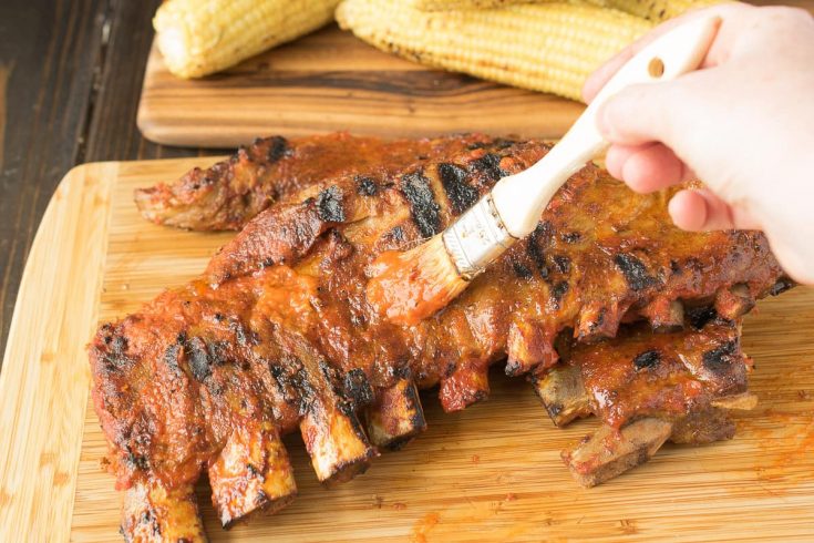Brushing barbecue sauce on spare ribs