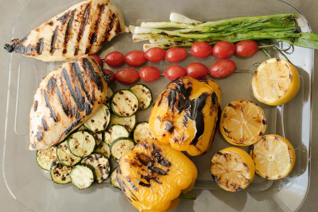 Grilled chicken and vegetables on a tray fresh off the grill