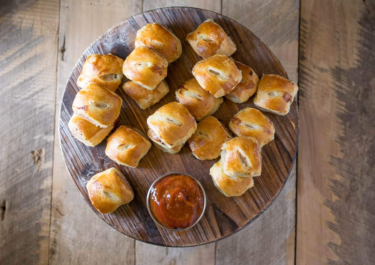An overhead image of the sausage rolls on a round board