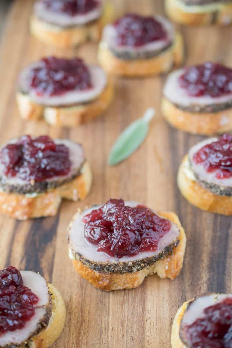 Toasted baguette slices topped with roast pork and cranberry sauce