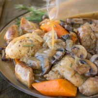 Pouring gravy over chicken and vegetables