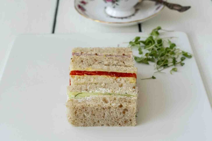 3 rectangle sandwiches with a cup of tea