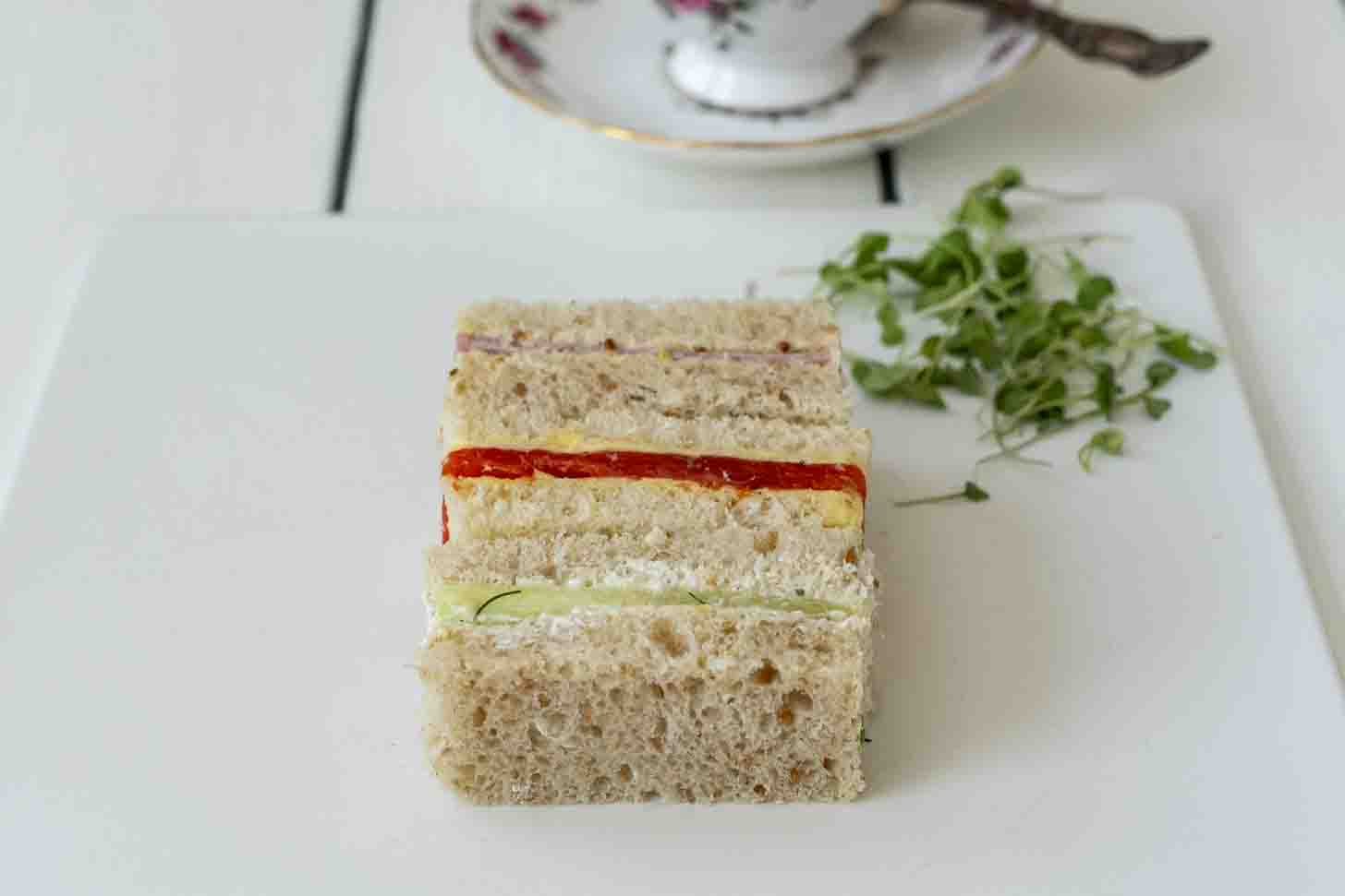 3 rectangle sandwiches with a cup of tea