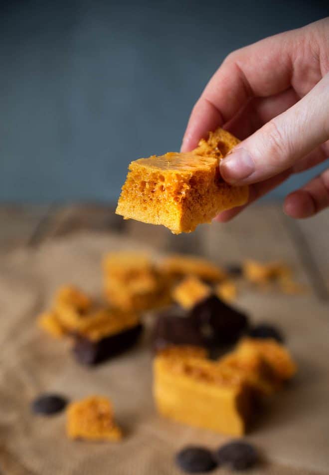 Holding a piece of 3 Ingredient Cinder Honeycomb Toffee