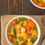30 minute winter vegetable soup viewed from overhead in a white bowl with a spoon