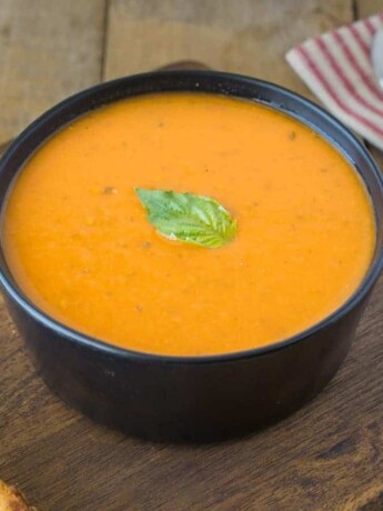A bowl of 30 minute tomato basil soup on a board