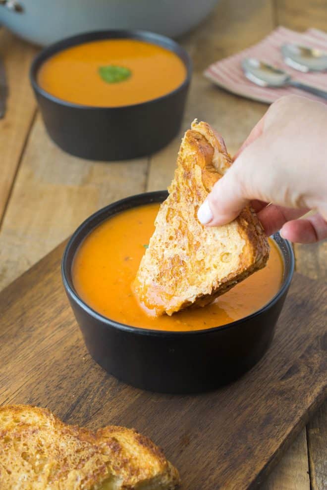 Dipping a grilled cheese sandwich in a bowl of 30 minute tomato basil soup