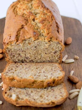 Almond banana bread on a cutting board with a butter knife