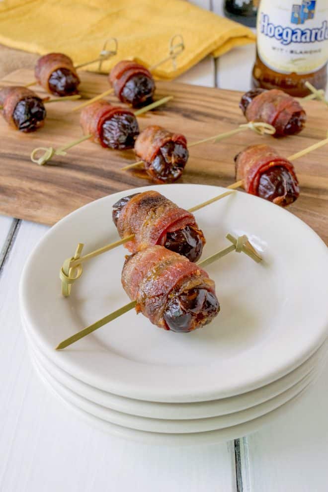 2 apple stuffed bacon wrapped dates on a white plate