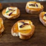 Toasted baguette slices topped with apricot preserves and white cheddar