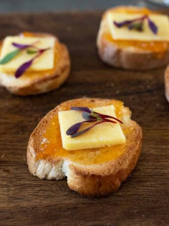Toasted baguette slices topped with apricot preserves and white cheddar