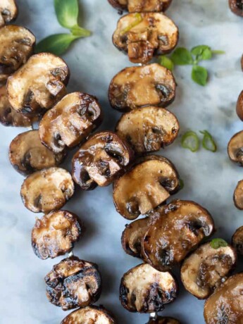 Mushrooms cut in half and threaded onto skewers and grilled