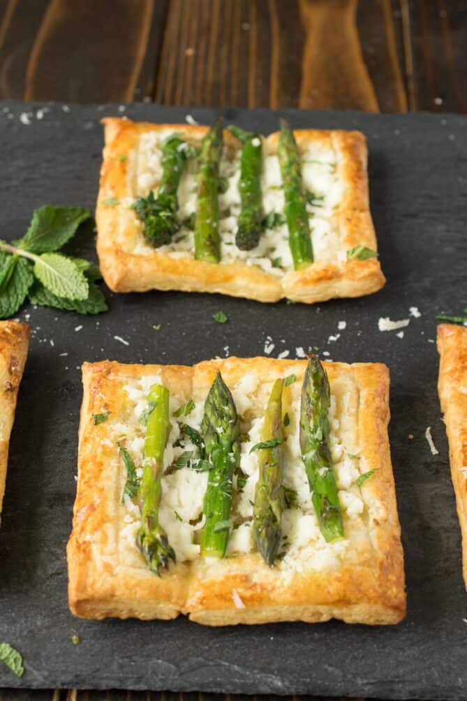 Square tarts made with puff pastry, ricotta, asparagus and mint