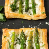 2 puff pastry squares topped with ricotta and asparagus spears