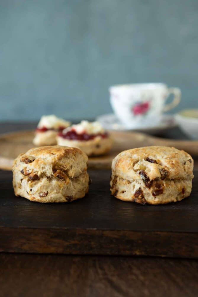 2 apple and date scones viewed from the side with a cup of tea