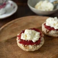 Clotted cream and strawberry jam on top of a scone half