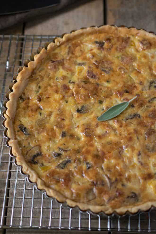 A whole quiche just out of the oven on a cooling rack