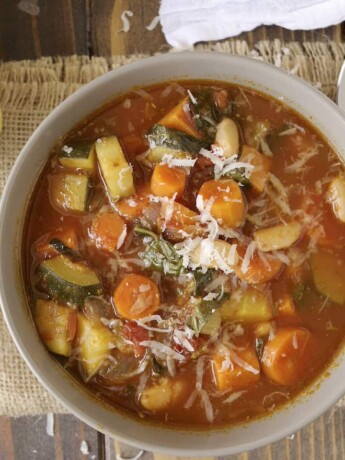 A bowl of minestrone soup with colorful vegetables from above
