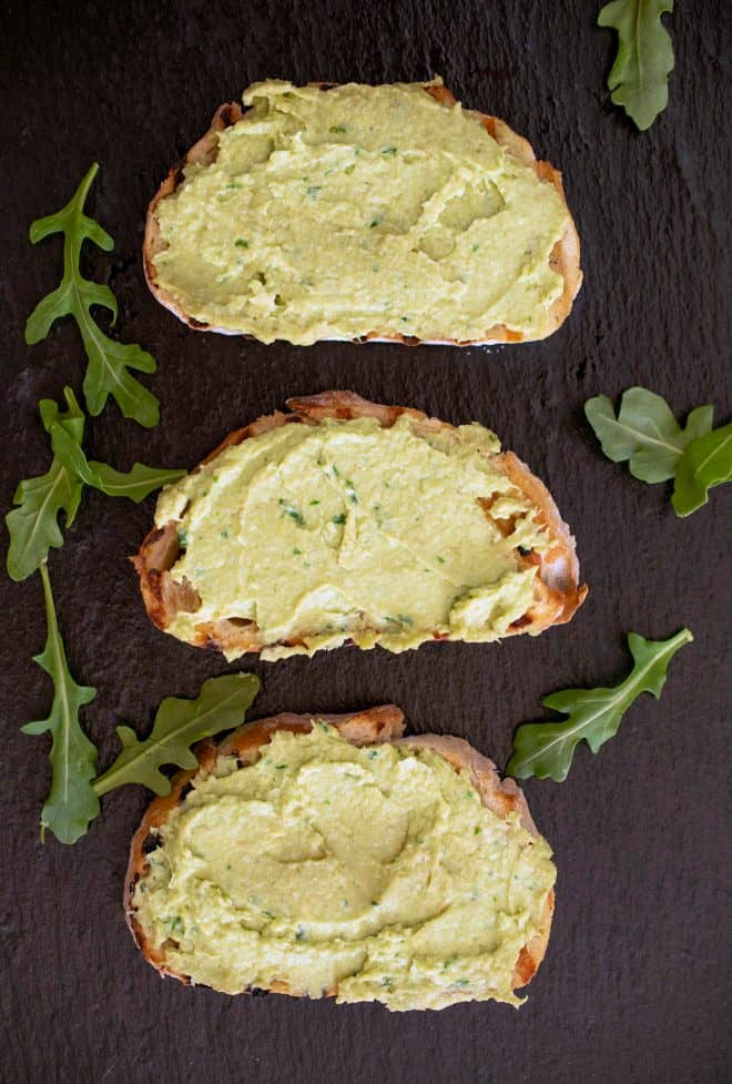 3 slices of toast topped with avocado and artichoke spread
