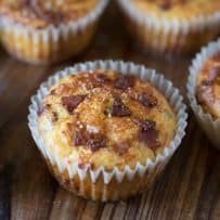 A bacon cheddar corn muffins with pieces of bacon on the top