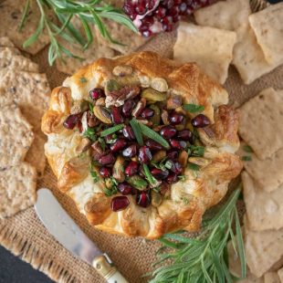 From overhead showing the pretty pomegranate seeds and rosemary on top of the baked brie