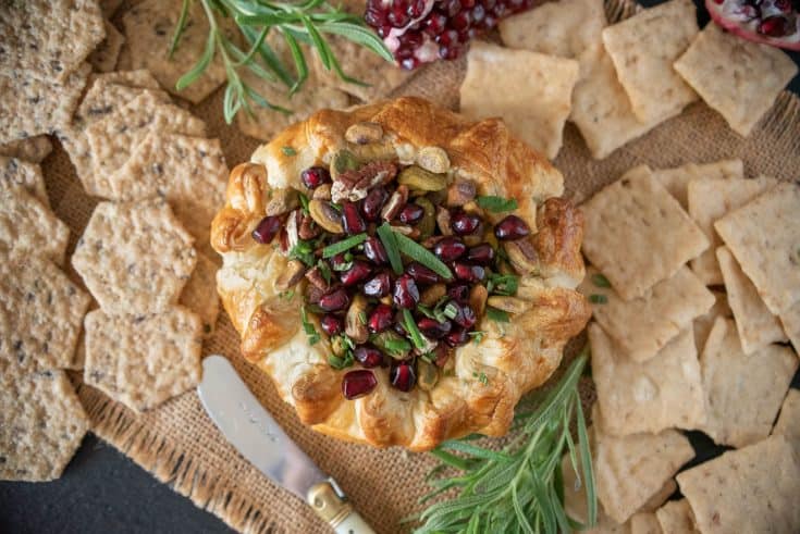 From overhead showing the pretty pomegranate seeds and rosemary on top of the baked brie