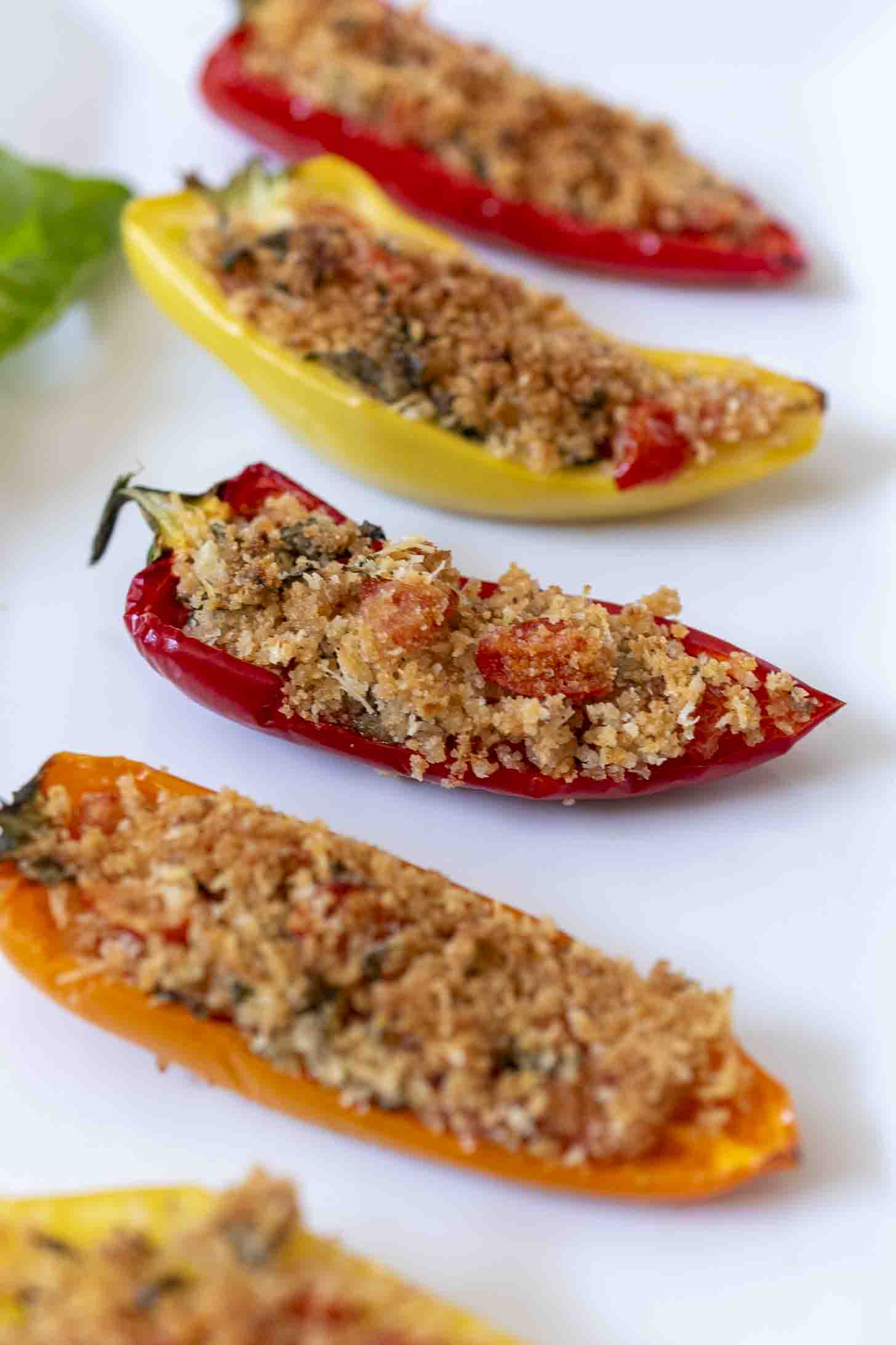 A row of mini red and yellow stuffed peppers