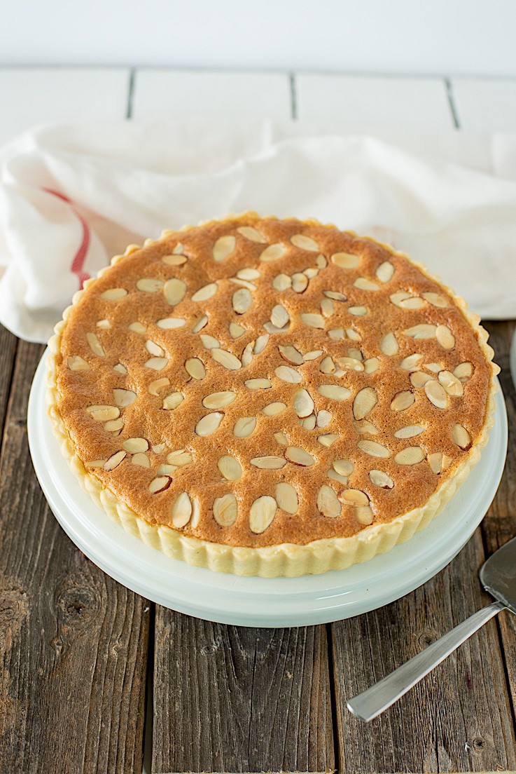 A classic bakewell tart with flaky pastry layered with jam and almond sponge topped with sliced almonds