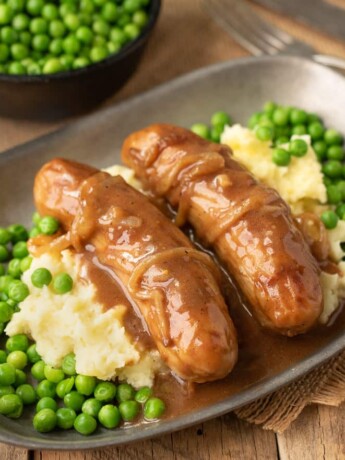 2 British bangers on a bed of mash with peas