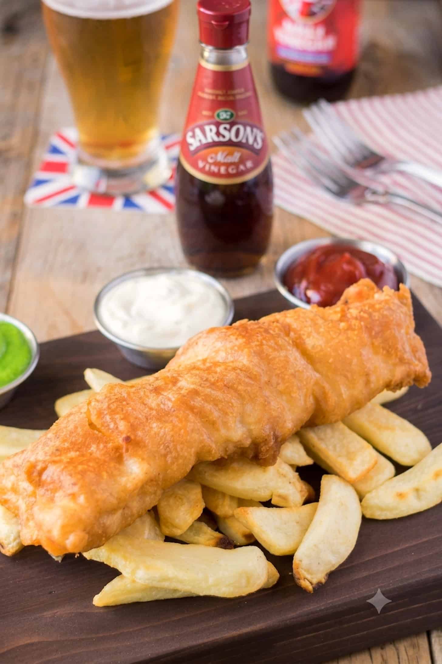 A long piece of fried fish on top of French fries