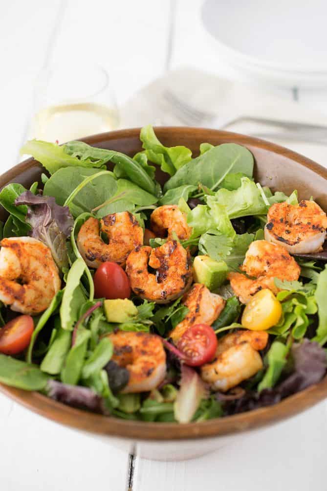 A closeup showing a perfectly charred grilled shrimp in the salad