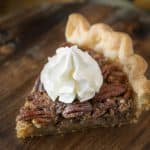 A slice of Bourbon Pecan Pie topped with whipped cream