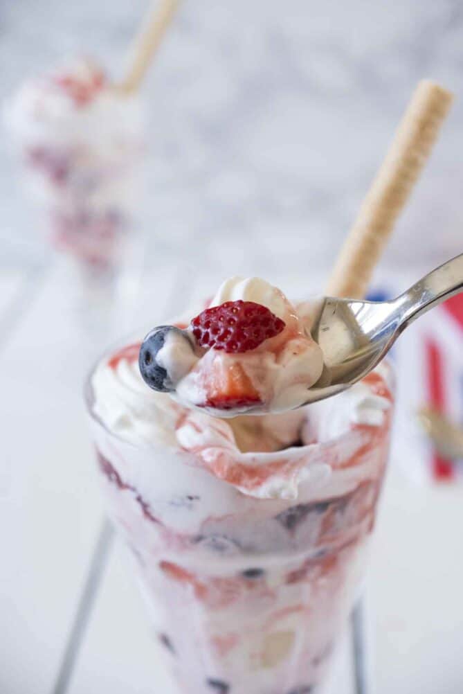A spoonful of ice cream, fresh strawberry and blueberry