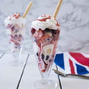 A Knickerbocker glory sundae with ice cream strawberries, blueberries and cream
