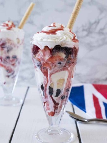 A Knickerbocker glory sundae with ice cream strawberries, blueberries and cream