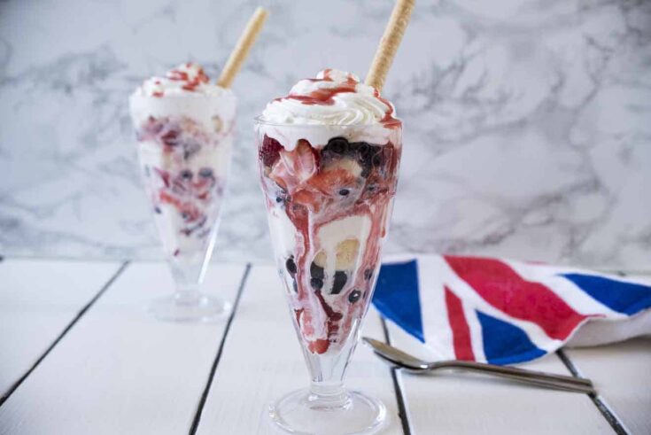 A Knickerbocker glory sundae with ice cream strawberries, blueberries and cream