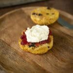 1 half of a pumpkin scone with cream and jam