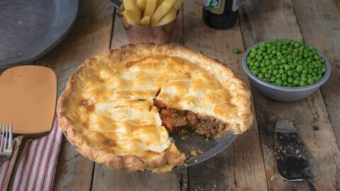 A piece of pie missing showing the chunks of beef and carrots inside
