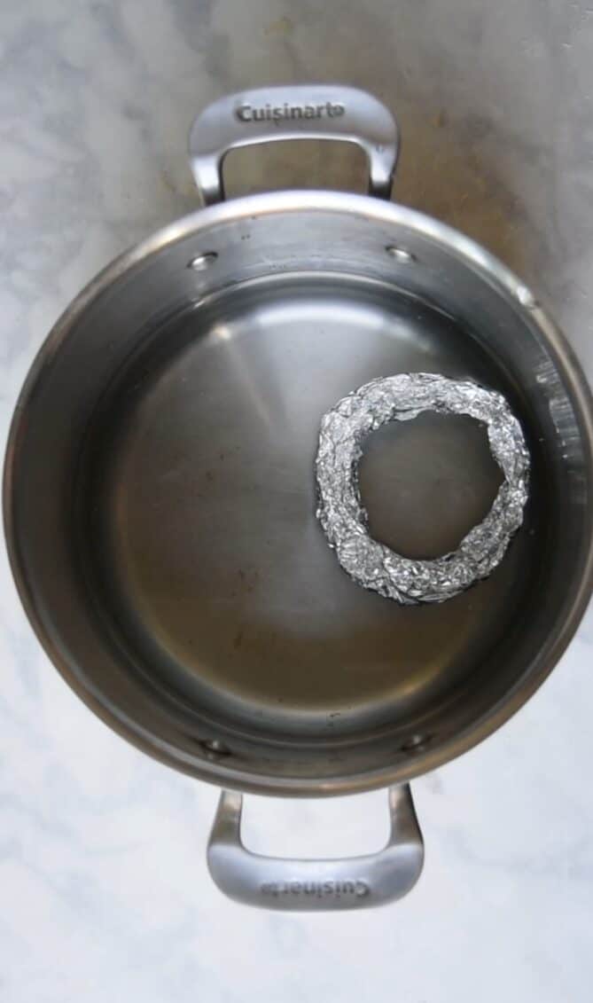 A pan filled with water with a ring of foil